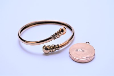Lot 64 - A 9ct gold circular pendant and a yellow metal bangle