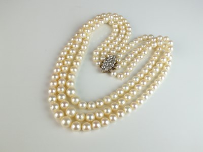 Lot 287 - A three strand cultured pearl necklace with diamond set clasp