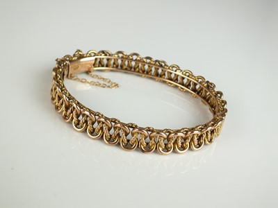 Lot 300 - A late 19th / early 20th century entwined scroll link openwork bangle