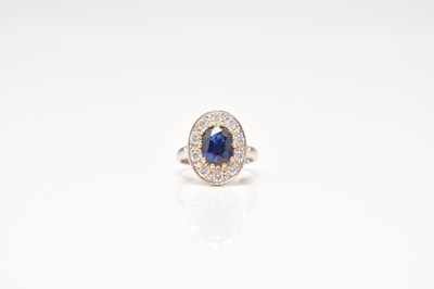 Lot 118 - An 18ct white gold sapphire and diamond oval cluster ring
