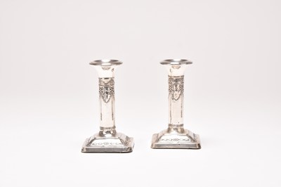 Lot 101 - A pair of Edwardian silver mounted candlesticks