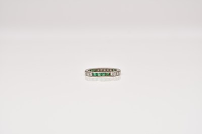 Lot 157 - A diamond and emerald eternity band