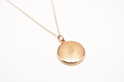 Lot 148 - A yellow metal circular locket on chain