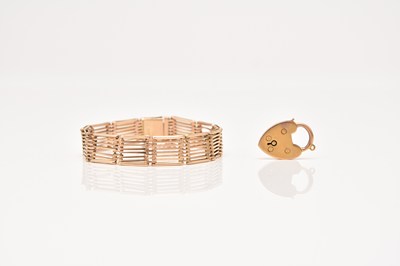 Lot 254 - A yellow metal eight bar gate bracelet and a padlock clasp